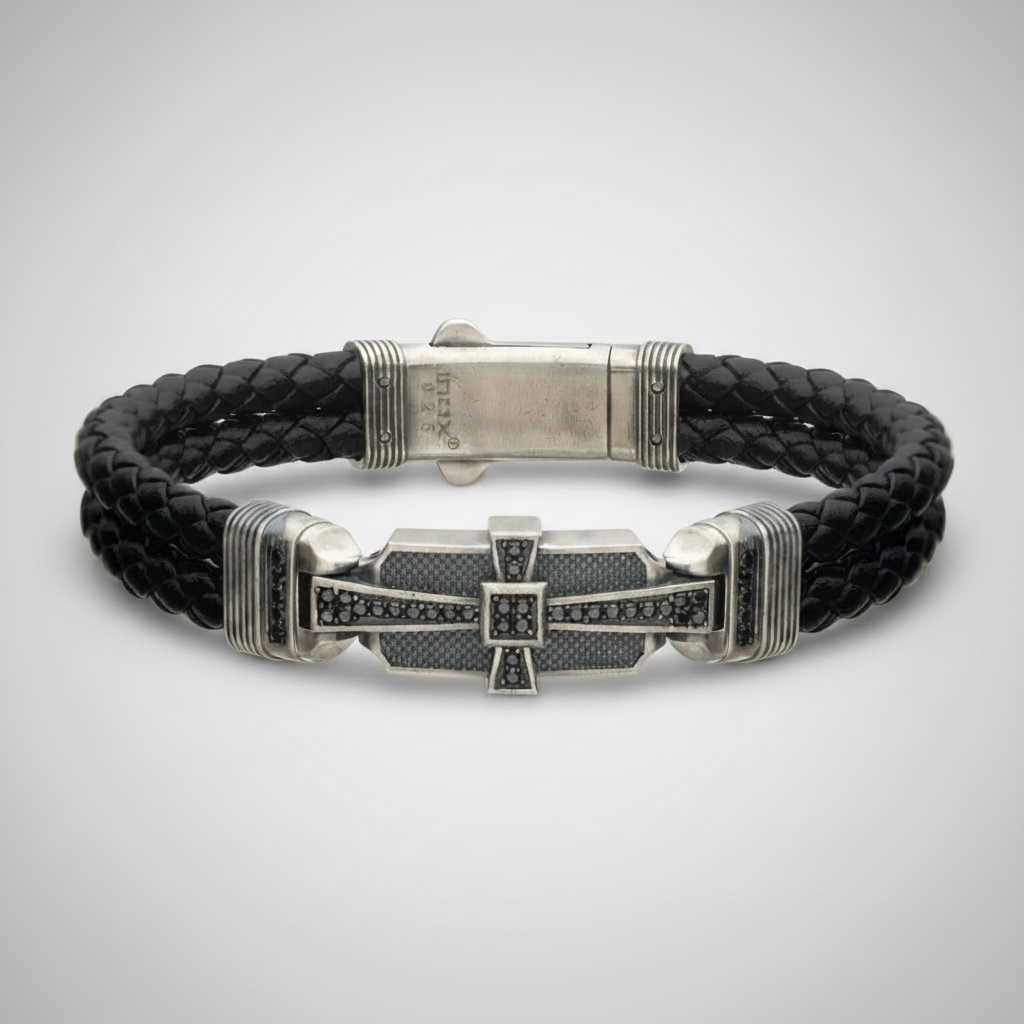 Double braid black leather bracelet with sterling silver cross on very light gray background